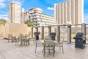 a group of chairs and tables on a patio with buildings at Royal Kuhio Resort in Honolulu