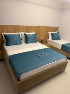 two beds with blue pillows in a room at TIA Layover Rooms in Krujë