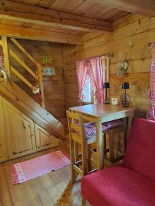 a wooden cabin with a table and a chair at Holiday Home Geppetto in Gornji Velemerić