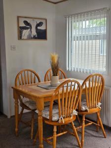 a dining room table with four chairs and a table at Vacanza Static Caravan in Tosside
