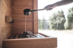 a person is pouring water into a barbecue grill at Fuxbau Allgäu in Argenbühl