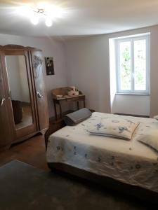 a bedroom with a bed and a dresser and a window at La Ferme Du Marronnier in Valence-dʼAlbigeois