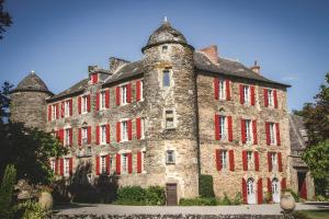 an old stone building with red shutters on it at La Ferme Du Marronnier in Valence-dʼAlbigeois