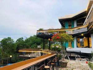 a balcony of a building with a pool and tables and chairs at THE NAM DU HILL resort in Nam Du
