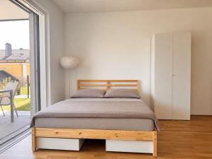 a bedroom with a bed and a large window at Lakeside Garden Ossiacher See in Sattendorf
