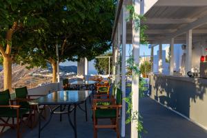an outdoor patio with tables and chairs and trees at Loft Kaves Pool & Bar Suites in Pyrgos