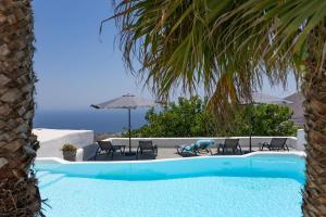 a swimming pool with chairs and an umbrella at Loft Kaves Pool & Bar Suites in Pyrgos