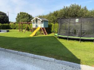 a playground with a slide and a play house at Cosy apartment - Na Creagáin in Tully
