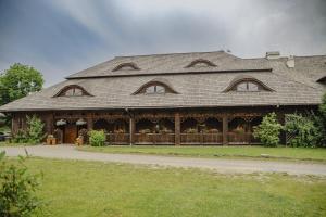 a large house with a fence in front of it at Karczma Regionalna Hotel GOŚCINNA CHATA in Wysowa-Zdrój