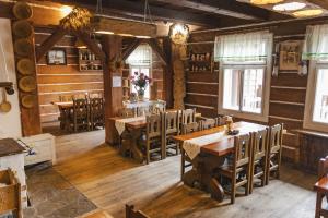 a restaurant with wooden floors and tables and chairs at Karczma Regionalna Hotel GOŚCINNA CHATA in Wysowa-Zdrój