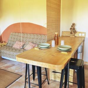 a wooden table with plates on it with a couch at Espace Bulle-Zen in Burlats +5 photos