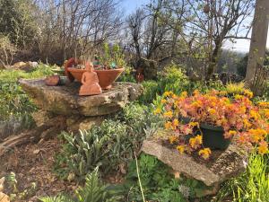 a garden with a statue and flowers on rocks at Espace Bulle-Zen in Burlats