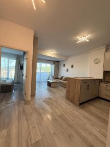 an empty kitchen and living room with wooden flooring at Urban Nest Florești in Floreşti +3 photos