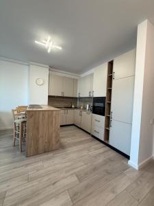 a large kitchen with white cabinets and a wooden island at Urban Nest Florești in Floreşti