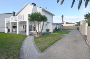 a white house with a palm tree in the yard at 9 on Dolfyn in Yzerfontein