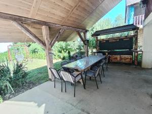 a patio with a table and chairs and a piano at Tiski raj in Bečej
