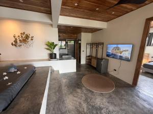 a living room with a couch and a flat screen tv at SANA Koh Phangan in Salad Beach