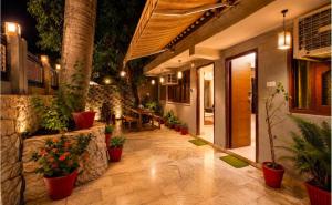 a patio with potted plants and a table in a building at The Peach Boho in Mount Ābu