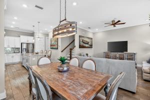 a kitchen and dining room with a wooden table and chairs at Mystic Seas in Watersound Beach
