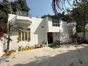 a white house with some plants in front of it at Sadhana kunj in Varanasi
