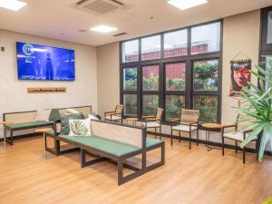 a waiting room with chairs and a flat screen tv at ibis Belem Aeroporto in Belém