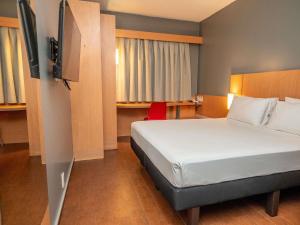 a hotel room with a bed and a desk at ibis Belem Aeroporto in Belém +86 photos