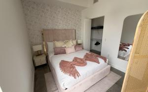a bedroom with a bed with white sheets and pink pillows at CD1608 Downtown Loft with Pool a Gym and City Views in Miami in Miami +24 photos