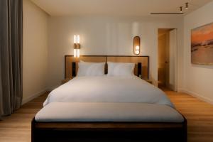 ein Schlafzimmer mit einem großen weißen Bett und zwei Kissen in der Unterkunft CASA METT Sitges - Fully refurbished in Sitges