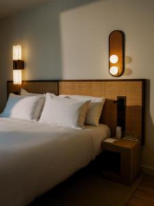 ein Schlafzimmer mit einem großen weißen Bett und einem Nachttisch in der Unterkunft CASA METT Sitges - Fully refurbished in Sitges
