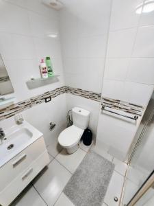 a white bathroom with a toilet and a sink at La Ola in El Médano