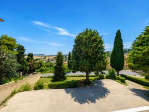 a park with two trees and a pathway at Konero Room in Loreto