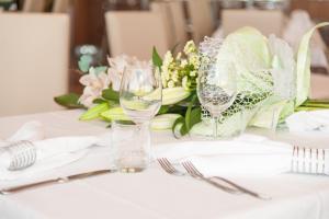 a table with two wine glasses and a bouquet of flowers at Hotel President in Bibione +70 photos