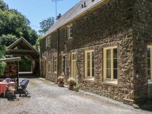 an old stone building with a table outside of it at Lukesland Wing in Ivybridge