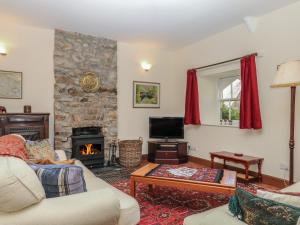 a living room with a couch and a fireplace at Lukesland Wing in Ivybridge