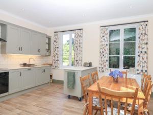 a kitchen with a wooden table and a dining room at Lukesland Wing in Ivybridge