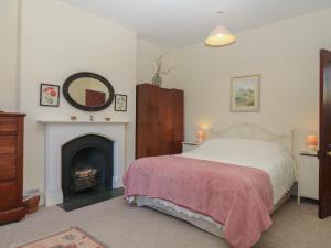 a bedroom with a bed and a fireplace at Lukesland Wing in Ivybridge