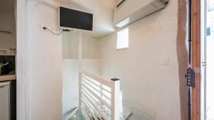 a room with a staircase with a tv on the wall at Rentbeat collection 3 historic center in Ostuni