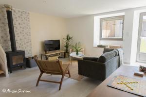 a living room with a couch and a fireplace at Maison Serrioux in Cholonge