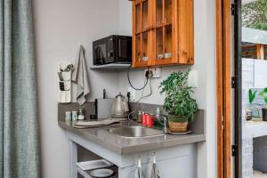 a kitchen counter with a sink and a microwave at Santa Stay in Stellenbosch +2 photos