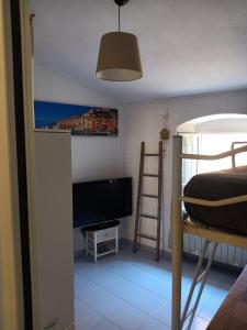 a bedroom with a bed and a television in a room at Casa Ida in Montemarcello