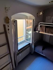 a small room with a window and a bunk bed at Casa Ida in Montemarcello