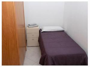 a small bedroom with a bed and a dresser at Casa Panorama in Monte di Procida