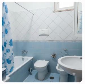 a blue and white bathroom with a toilet and a sink at Casa Panorama in Monte di Procida