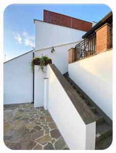 a stairway leading up to a white wall with a plant at Casa Panorama in Monte di Procida
