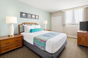 a bedroom with a large bed and a television at Royal Kuhio Resort in Honolulu +17 photos