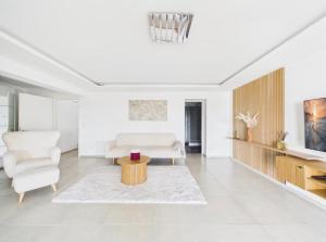a white living room with a couch and a table at Villa Rima in Vonyarcvashegy