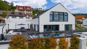a white house with a swimming pool in front of it at Villa Rima in Vonyarcvashegy