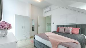 a bedroom with a large bed with pink pillows at Villa Rima in Vonyarcvashegy +12 photos