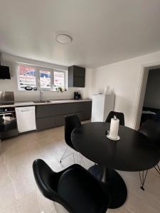a kitchen with a black table and black chairs at SeaviewHouse Rudkøbing in Rudkøbing