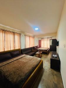 a hotel room with a bed and a couch at Green Hills Cottage in Aravankādu